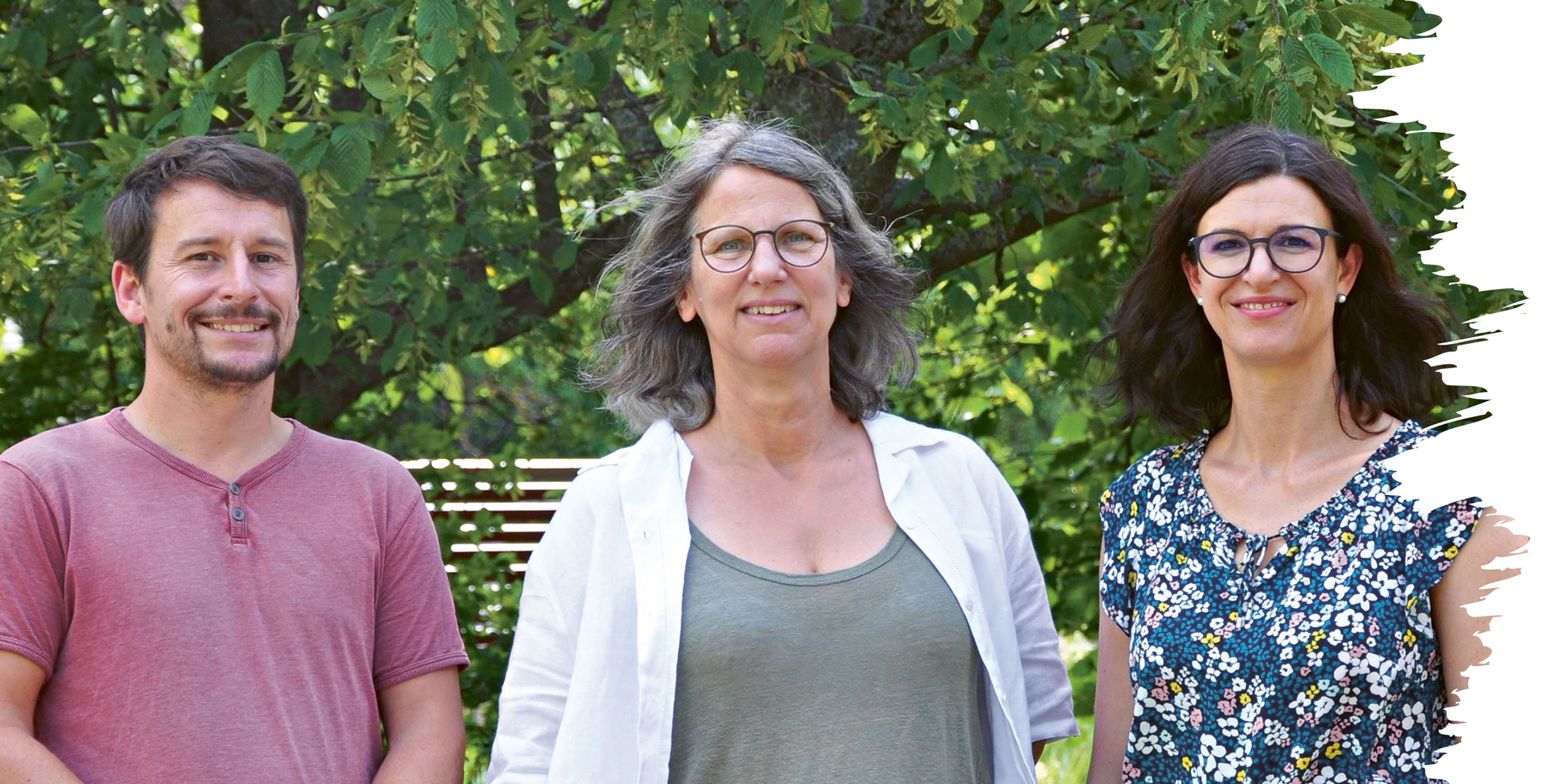 Links Fabian Horn im roten T-Shirt, in der Mitte Ines Körner mit weißer Bluse und Brille und rechts Anke Spiegel-Vogelsang mit dunklen Haaren und geblümtem Oberteil. Alle schauen in die Kamera und lächeln.